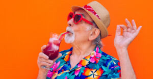 Man in heart sunglasses drinking a cocktail