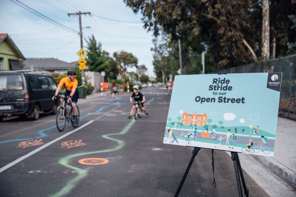 Kids riding past Ride & Stride sign