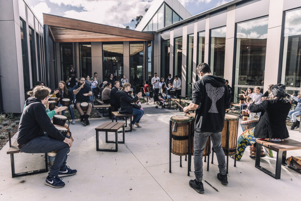 People drumming in building courtyard