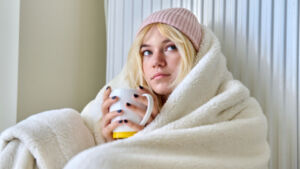 woman wrapped in a blanket holding a warm cup of tea