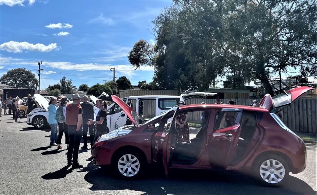 People standing around an EV