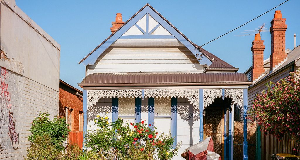 A small weatherboard terrace house in an inner city street.