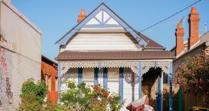 A small weatherboard terrace house in an inner city street.