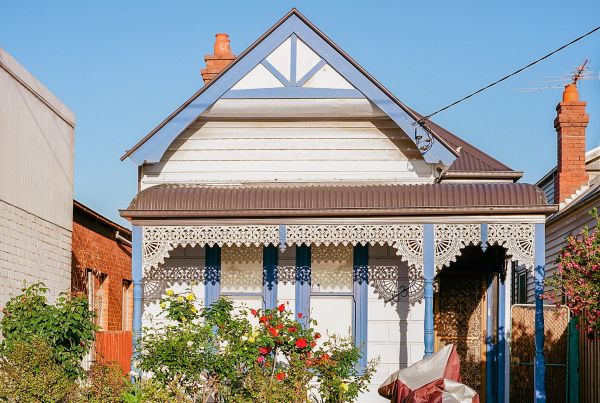 A small weatherboard terrace house in an inner city street.