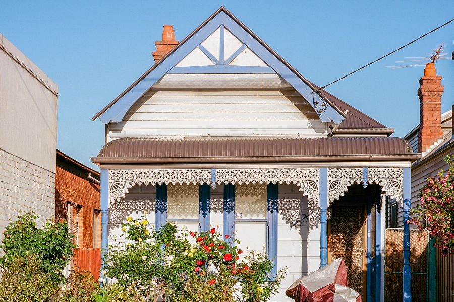 A small weatherboard terrace house in an inner city street.