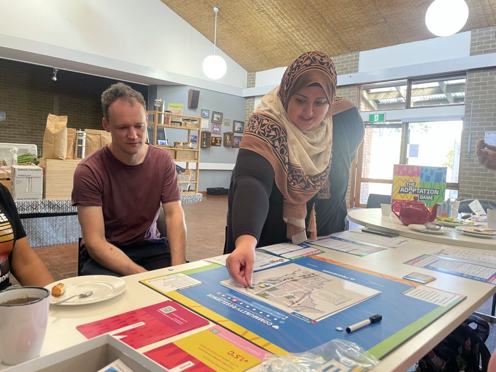 Two people playing a board game in a community hall.