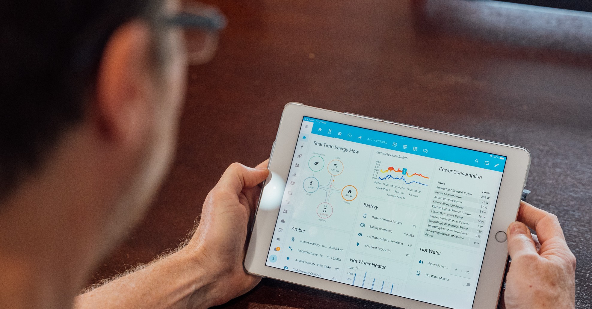 Person holding electronic tablet with energy information on screen