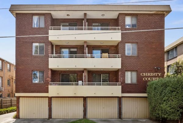 Brown brick apartment block with four stories.
