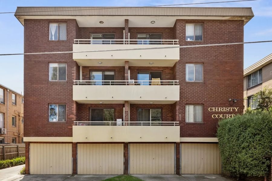 Brown brick apartment block with four stories.