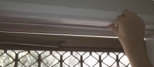 Photo of someone's hand applying weather sealing to a door.