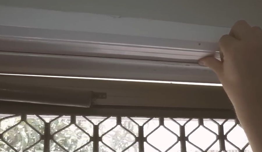 Photo of someone's hand applying weather sealing to a door.