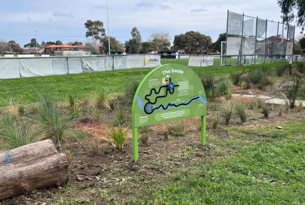 Photo of parkland with lots of plants in front of a football oval. Signage with words The Swale.