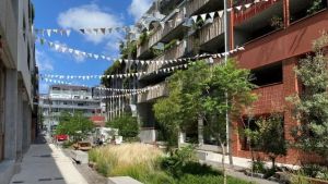 Apartment blocks with trees and greenery and bunting between the buildings