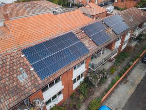 A red brick apartment low-rise apartment block with solar on the roof.