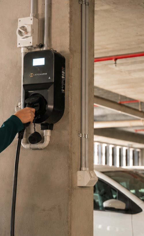 A person plugging their EV into a Level 2 charger