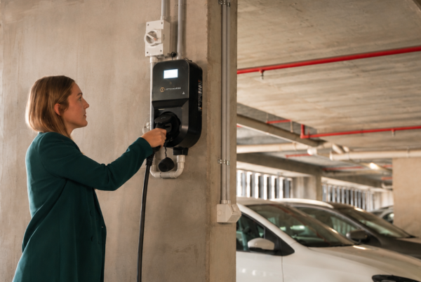 A person plugging their EV into a Level 2 charger