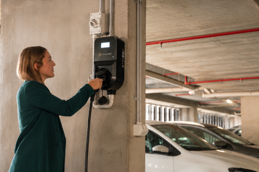 A person plugging their EV into a Level 2 charger